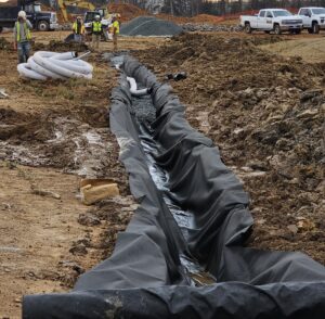 Drainage ditch lined with black fabric.