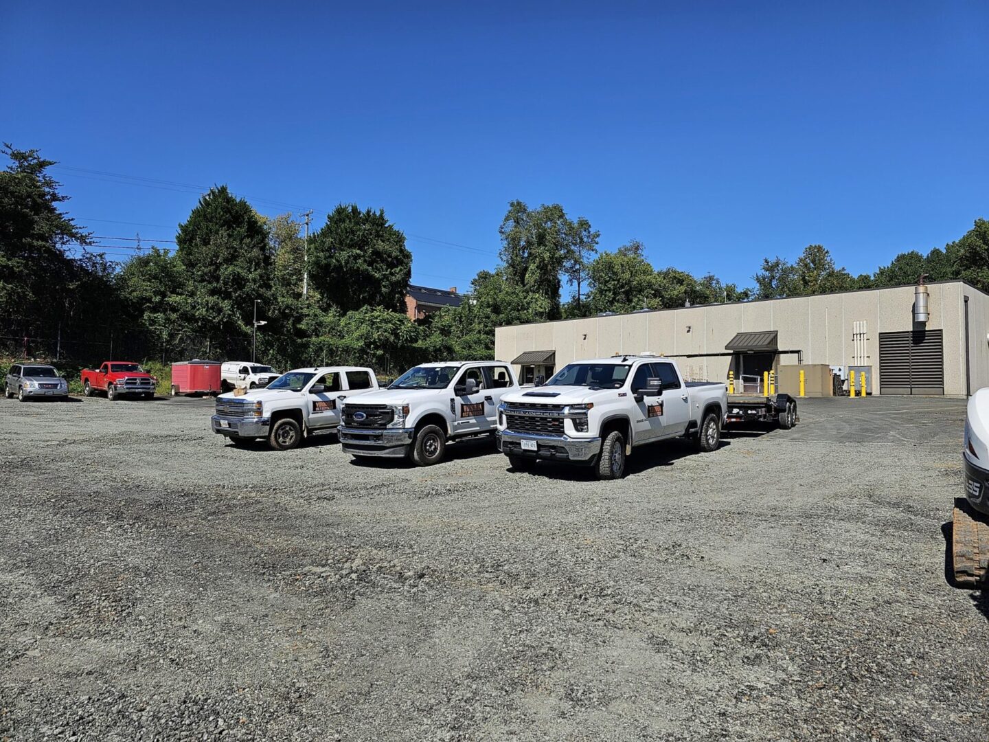 Four white trucks parked in a lot.