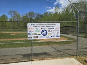 HCCA community service project sign at ball field.