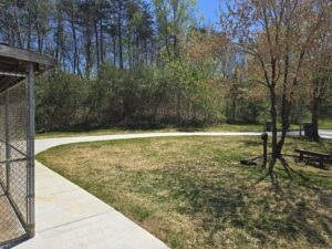 Concrete path leading to grassy field.