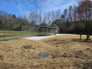 Baseball field with dugouts and fence.